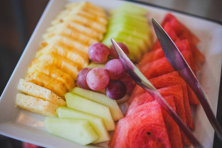 Sliced fruit mix on a plate, orange, watermelon, grape.