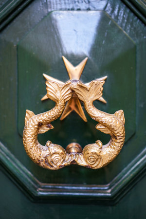 Close up color image of a vintage metal knocker on a wooden door.の写真素材