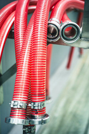 Close up shot of some flexible red hoses with metal nozzles.の写真素材