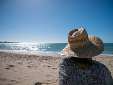 girl with sun hat relaxing at the beachの写真素材