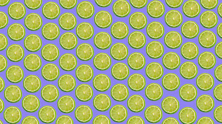 Colorful pattern of ripe lime slices on a purple and lilac background.の写真素材