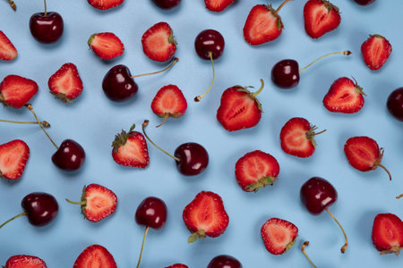background of ripe strawberries and cherries on a blue background.Trendy,fruity,summer loop backgroundの写真素材
