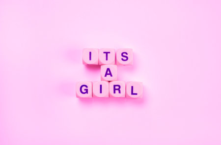 pink background with text from the cubes - its a girl, the concept of a newborn girlの写真素材