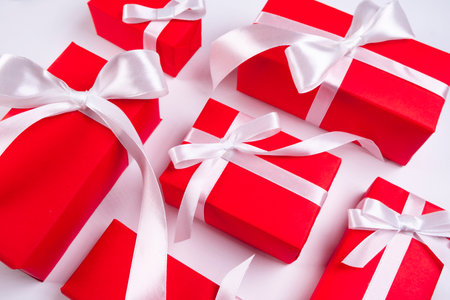 background with red festiv boxes with ribbons and bows or gifts on white background,concept for new year christmas,valentines day or holidaysの写真素材