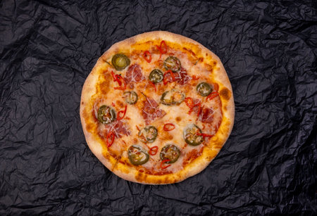 pizza spicy chorizo with jalapeno peppers close-up on a black backgroundtop viewの写真素材