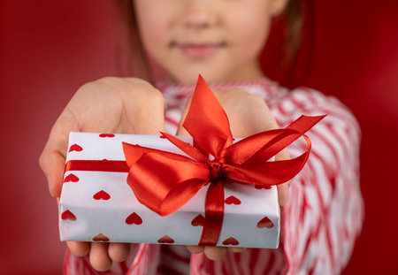 Unrecognizable boy in santa hat holding christmas or new year gifts in his handsの写真素材