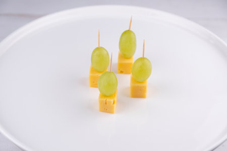 cheese and grape canapes on white plate or background closeup,snack conceptの写真素材