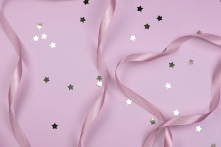 pink festive delicate pastel background with satin ribbons and golden stars , the concept of the birthday of a newborn girl, ballet, to insert textの写真素材
