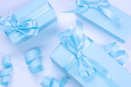 blue gift boxes with blue bows on a blue background, top view, the concept of celebrating a boy or mans birthday, a party or an anniversary or a newbornの写真素材
