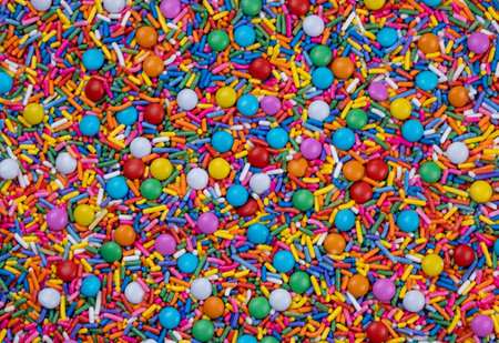 background of multi-colored sprinkles for sweets and multi-colored dragees or sweets. The concept of celebrating a birthday, party or other holidays. trendy, sweet backgroundの写真素材
