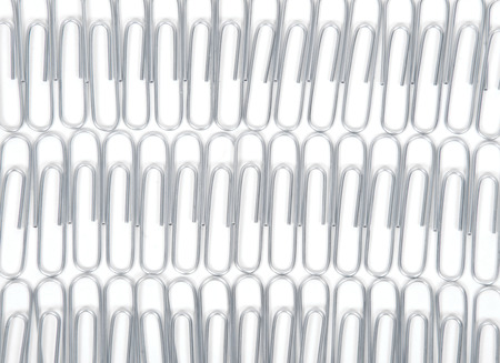 Metal paper clips separated on white backgroundの写真素材