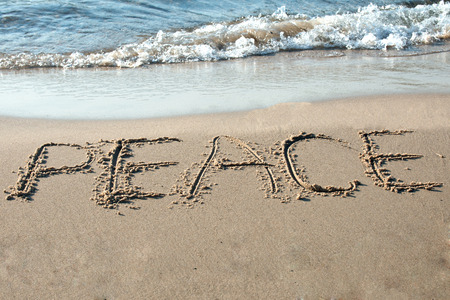 Peace written in the sand on the beachの写真素材