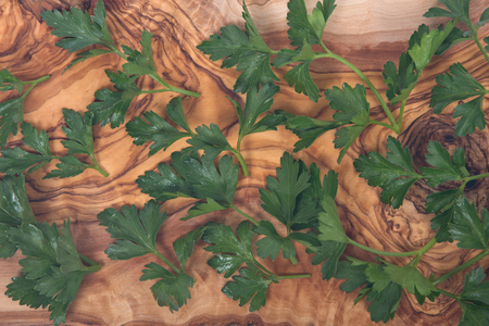 Fresh organic italian parsley on olive wood cutting boardの写真素材