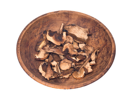 Dried porcini mushroom in wooden bowl isolated on white backgroundの写真素材
