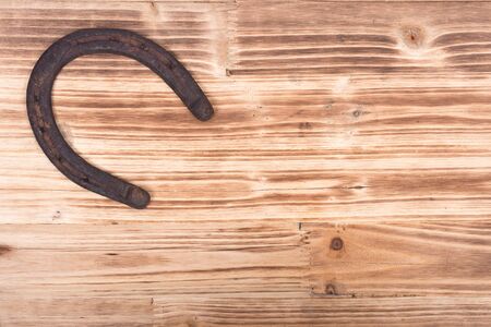 Old rusty vintage good luck horseshoe on wooden tray like backgroundの写真素材