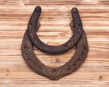 Old rusty vintage good luck horseshoe on wooden tray like backgroundの写真素材