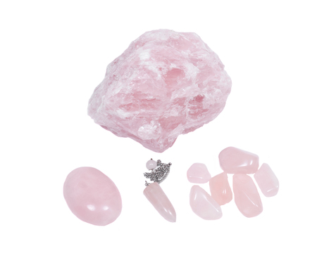 Rose quartz chunk, pendulum, cabochon, and tumbled stones isolated on white background