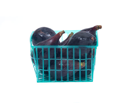 Fresh ripe organic figs in green plastic basket isolated on white backgroundの写真素材
