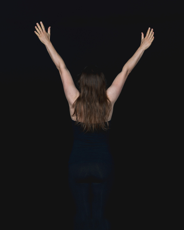 Young active woman stretching her arms above her head awaiting sunriseの写真素材