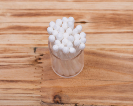 Organic double end cotton ear and make up swabs, buds on wooden vintage background
