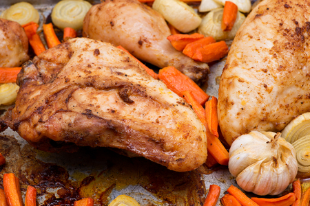 Roasted chicken, carrots, onion and garlic in metallic roaster oven panの写真素材