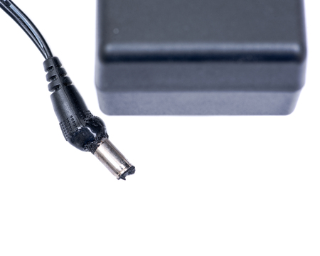 Burned AC Power Adapter, Charger for External Hard Drive Plug in Cable isolated on white backgroundの写真素材