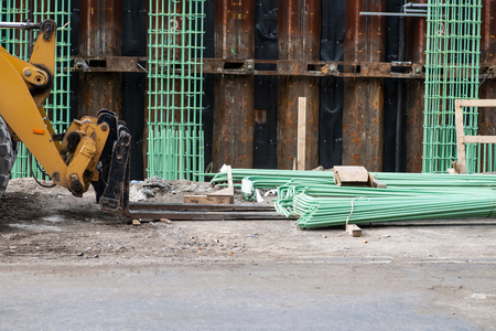 Workers are installing green welded wire steel mesh reinforcement for concrete construction