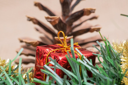 Winter holiday decoration: tinsel garland, Christmas gift decor and pine cone on burlap backgroundの写真素材