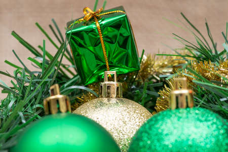 Winter holiday decoration: tinsel garland with Christmas gift decor and colorful tree balls on burlap background.の写真素材