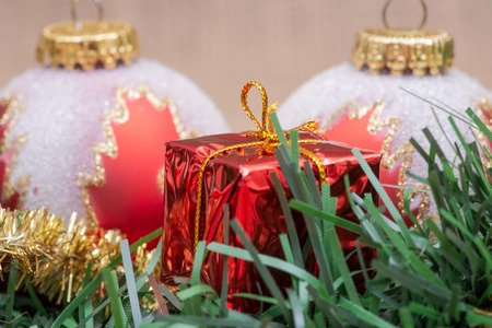 Winter holiday decoration: tinsel garland with Christmas gift decor and colorful tree balls on burlap background.の写真素材