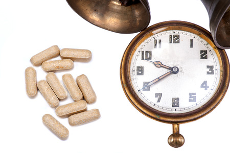 Concept for whom the bell tolls: old vintage pocket watch, bells and medical pills isolated on white background.の写真素材