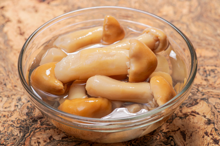 Marinated wine cap mushrooms. Stropharia rugoso annulata mushrooms in clear glass bowlの写真素材