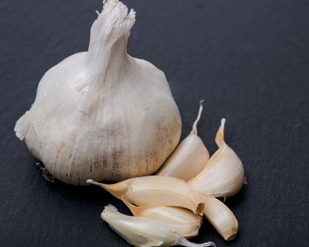 Fresh ripe organic garlic on natural stone background.の写真素材