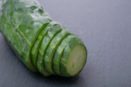 Fresh sliced organic cucumber on natural stone background.の写真素材