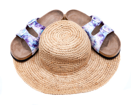 Purple Double Strap Sandals with a colorful print on the faux leather straps, with a soft micro suede foot bed and cork out-sole partially covered with stylish straw summer tan hat. White background.の写真素材