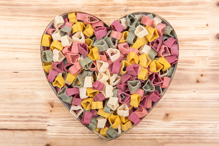Durum wheat semolina heart-shaped 5 flavors pasta with vegetables in heart shaped container. Valentine's Day.の写真素材