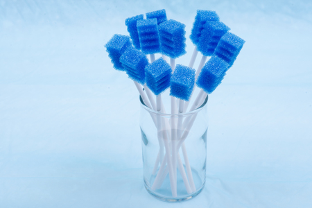 Untreated disposable oral swabs on blue under pad.の写真素材