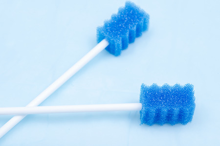 Untreated disposable oral swabs on blue under pad.