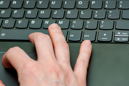 Closeup of business woman hand busy typing on laptop keyboard trying to access data.