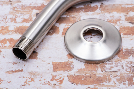 Brushed Nickel Metal Shower Arm and Flange isolated on brick wall background.の写真素材