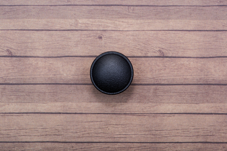 Classic Black Round Cabinet Knob isolated on wooden background.の写真素材