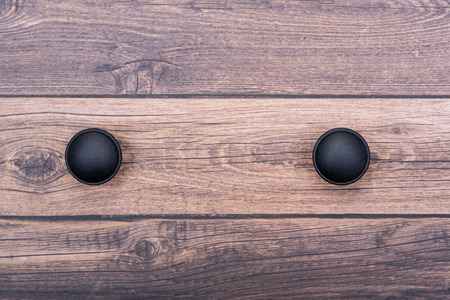 Classic Black Round Cabinet Knob isolated on wooden background.の写真素材