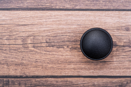 Classic Black Round Cabinet Knob isolated on wooden background.の写真素材