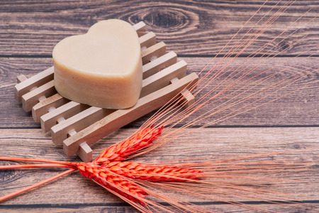 Wooden Soap Holder with a Heart shaped Goat milk Soap on wooden background.の写真素材