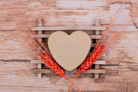 Wooden Soap Holder with a Heart shaped Goat milk Soap on wooden background.の写真素材