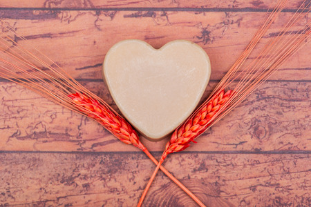 Wooden Soap Holder with a Heart shaped Goat milk Soap on wooden background.の写真素材