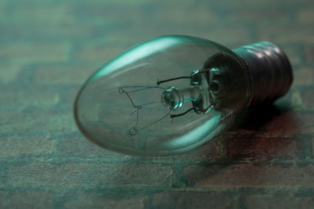 Clear Incandescent Night Light Bulb with candelabra base on green background.の写真素材