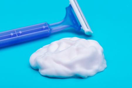 Disposable Women Razor and shaving foam isolated on blue background.の写真素材