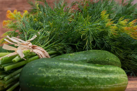 Fresh Organic Cucumber and Dill tied with a straw, on wooden background.の写真素材