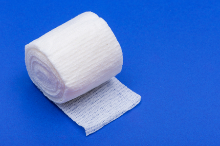 Hospital Grade Sterile White Rolled Gauze on blue background.の写真素材